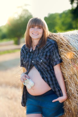 Foto Schwangere mit Babyschuhen auf dem Bauch