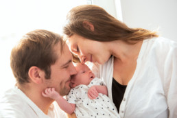 Babyfoto neugeborenes Baby schmust mit seinen Eltern