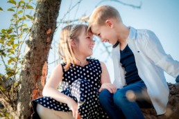 Geschwisterfoto , Bruder und Schwester sitzen auf einem Baum