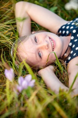 Kinderfoto, Mädchen liegt auf einer Wiese