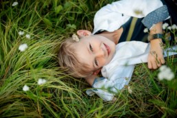 Kinderfoto, Junge liegt auf einer Wiese