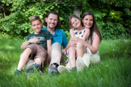 Familienfoto, Familie sitzt auf einer Wiese