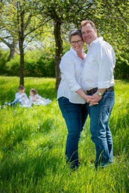 Foto Familienfoto Vater und Mutter im Vordergrund, Kinder im Hintergrund