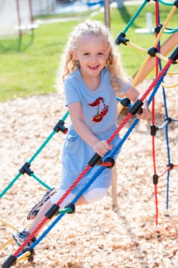 Foto Mädchen im Kindergarten auf Klettergerüst