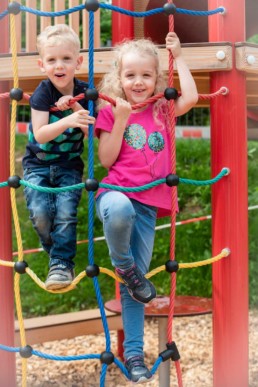 Foto Geschwister im Kindergarten auf Klettergerüst