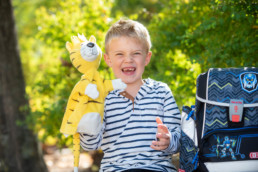 Foto Erstklässler mit Schulranzen und Handpuppe Mathetiger