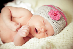 Babyfoto, Baby mit Häkelmütze schläft