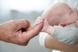 Foto Baby hält den Finger seines Vaters, kleine Hand und große Hand