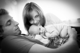 Foto neugeborenes Baby liegt auf dem Bauch seines Vaters, mit Mutter, Familienfoto