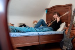 Marlene auf ihrem Bett mit E-Bass und Katze- Fotoprojekt Nur-so-halb von Stefanie Morlok Fotografin